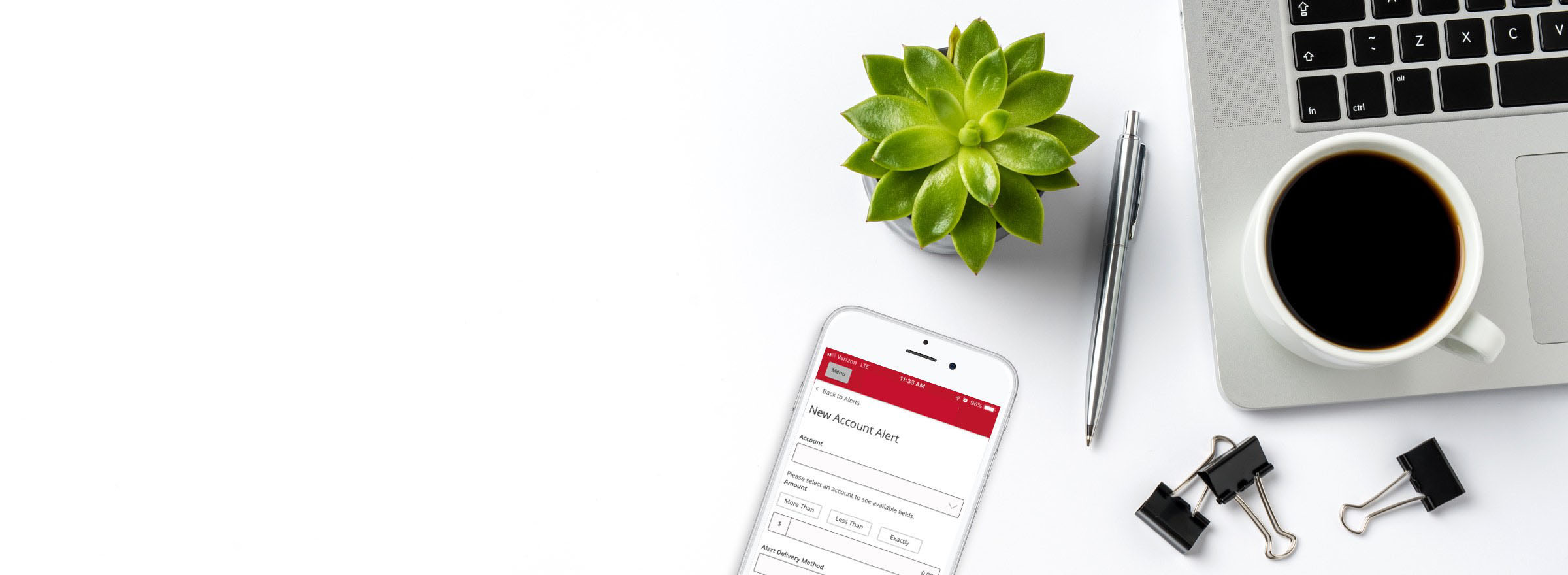 Phone with Highridge Credit Union app alerts screen, laptop on tabletop