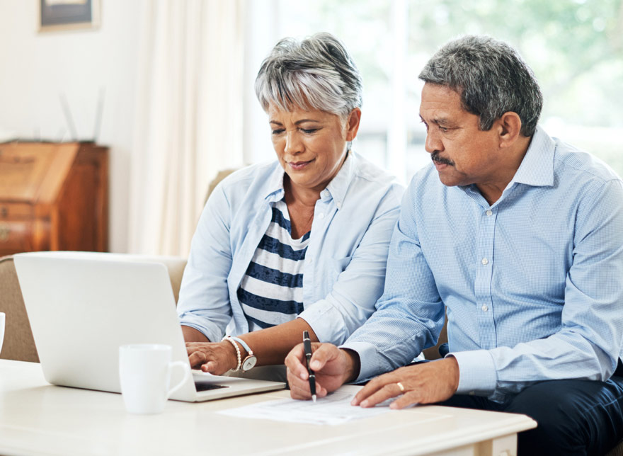 Husband and wife looking at their Highridge Credit Union account on the computer together.